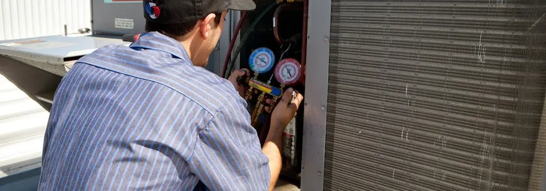 HVAC technician servicing a condenser unit in Pelican Bay